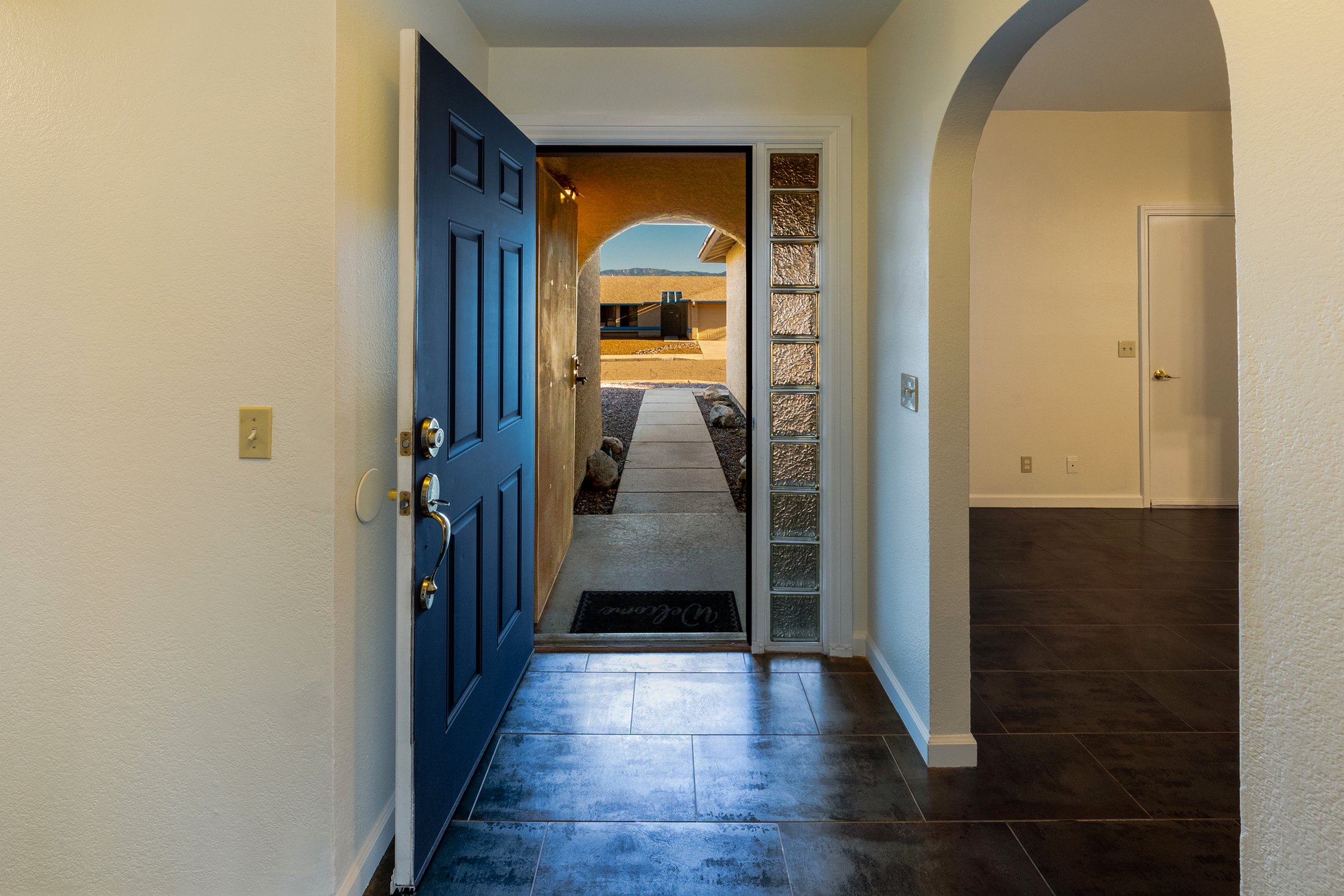 Open front door to the arched foyer and mountain view beyond.
