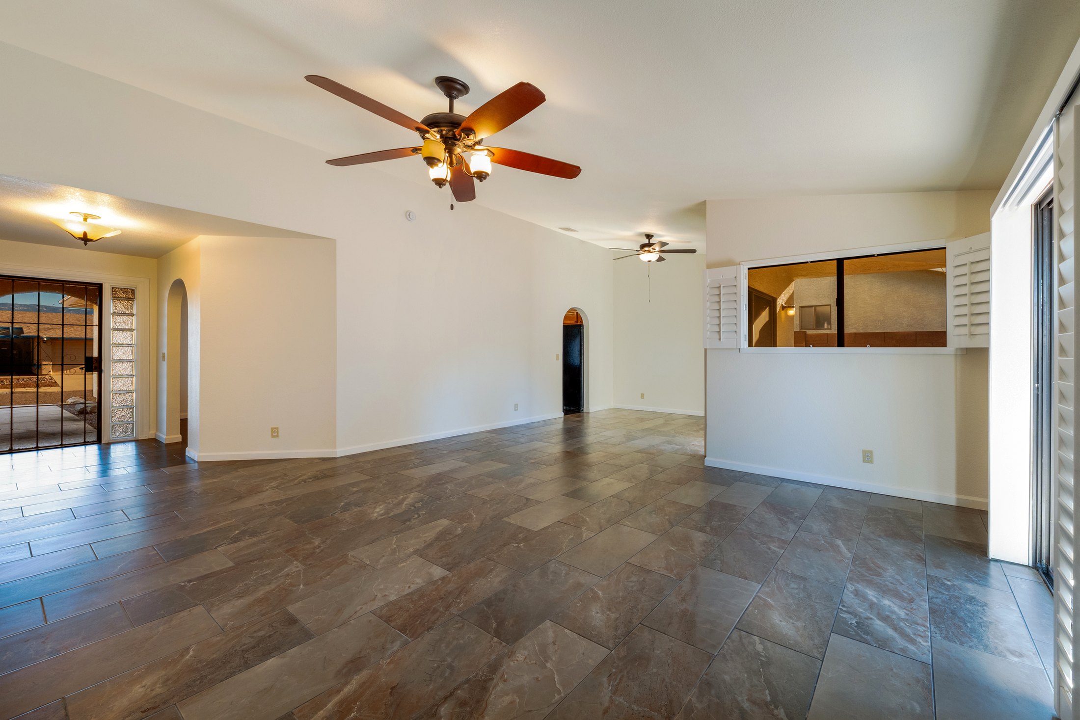 Vaulted living space with tile floors and light from the patio doors.