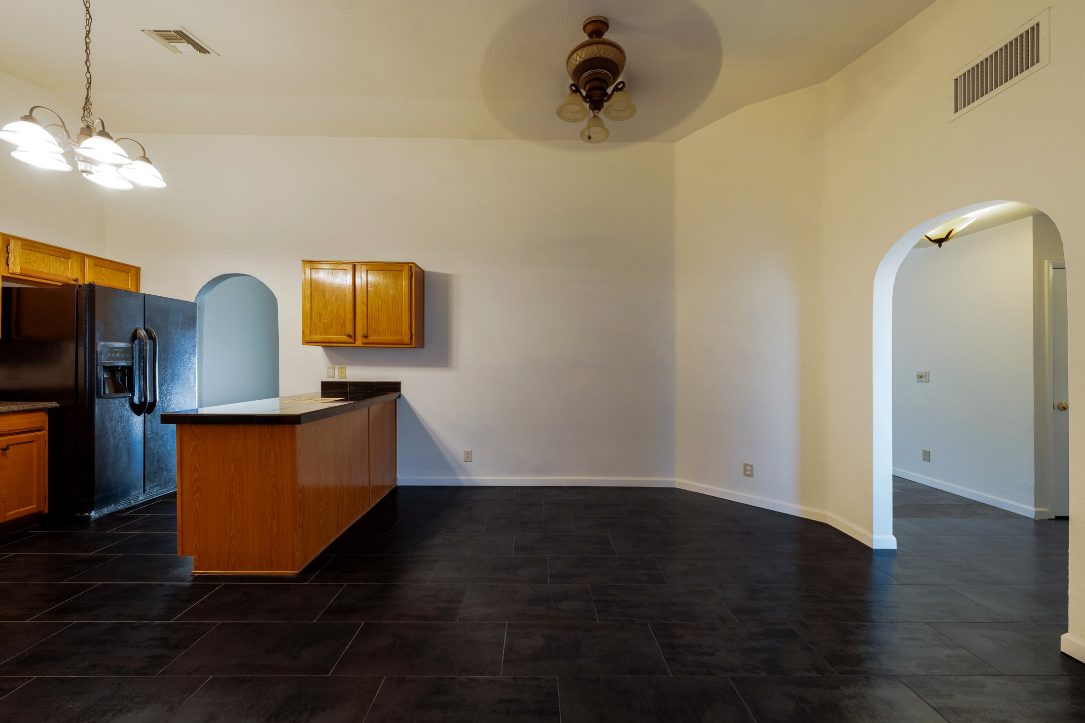 Open kitchen-dining pass with vaulted height and arched hall.