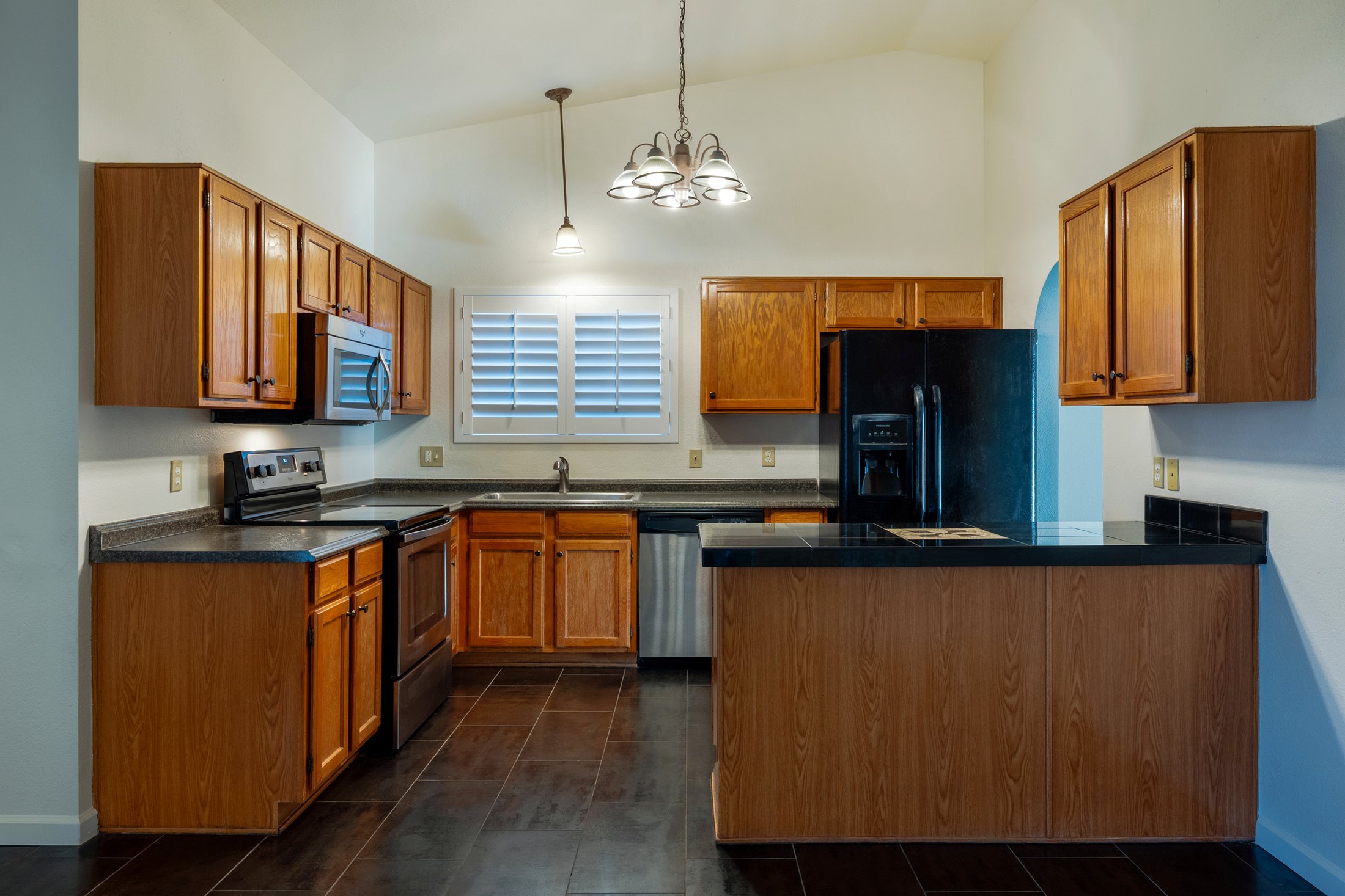 Oak cabinets, breakfast bar, and stainless appliances.
