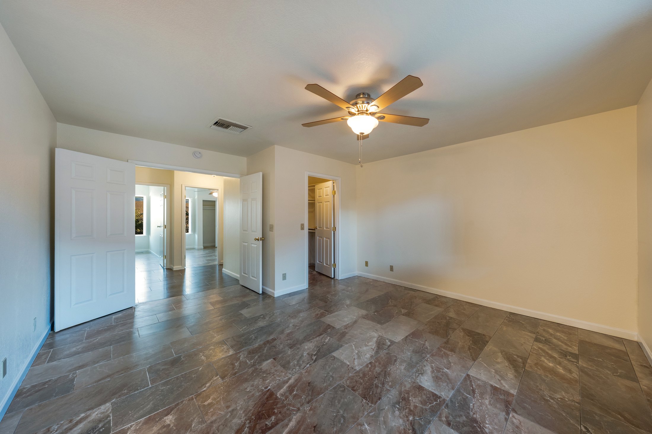 Primary bedroom with double doors and walk-in closet.