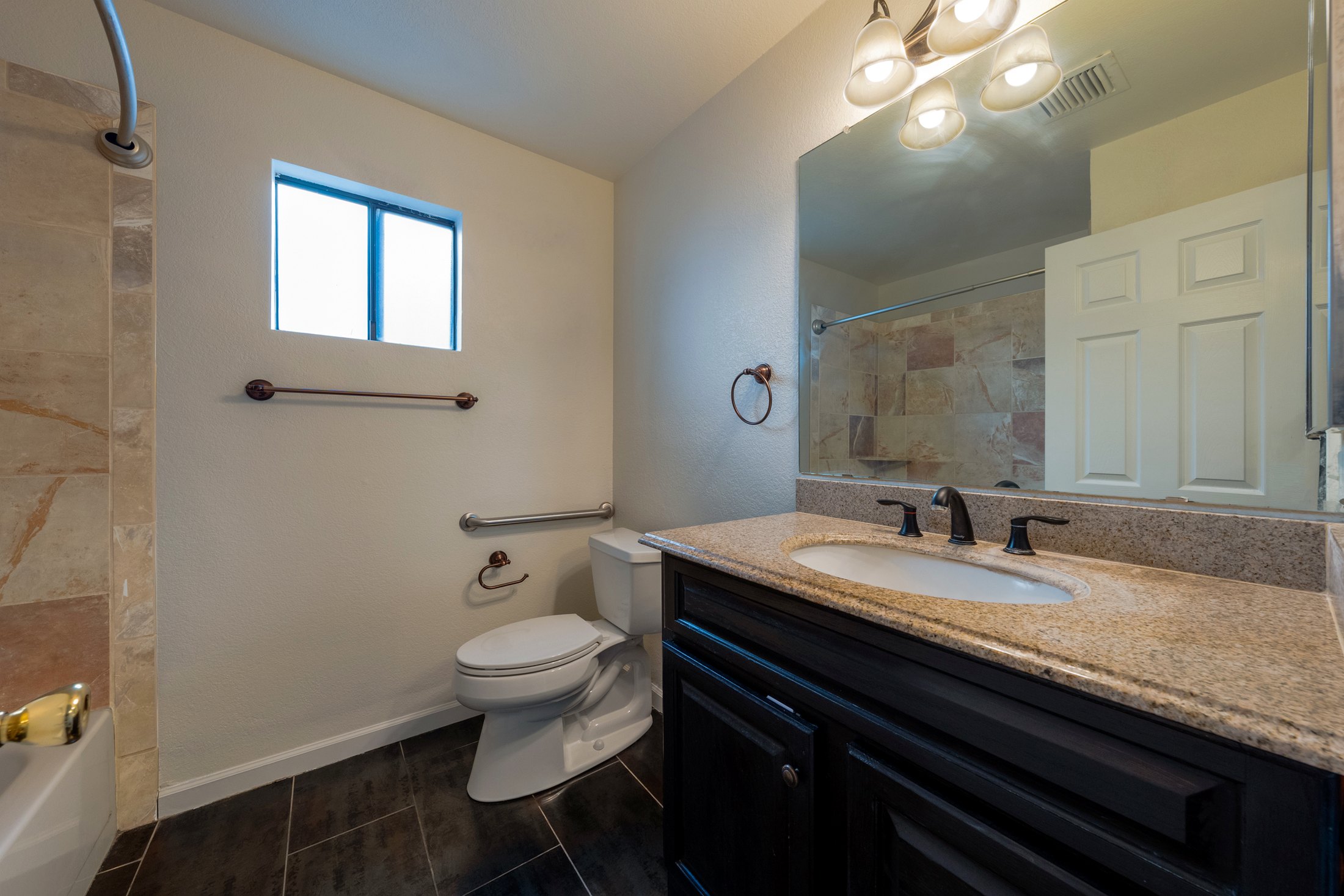 Hall bathroom with vanity and tile.