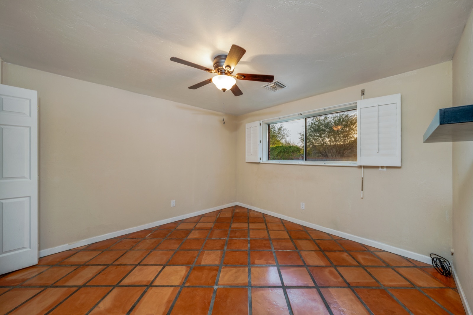 Third bedroom with a ceiling fan and shuttered window