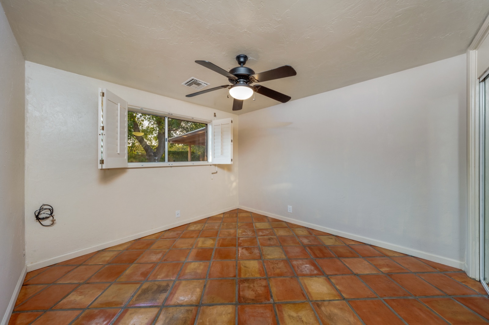 Fourth bedroom with tile floors and a broad window