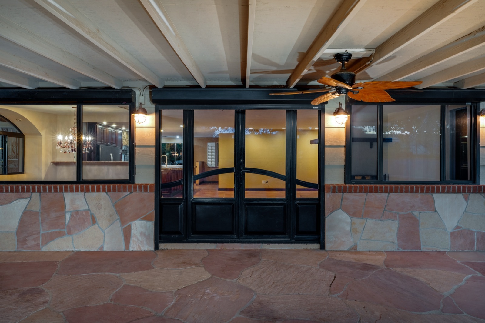Covered stone patio outside the glass doors