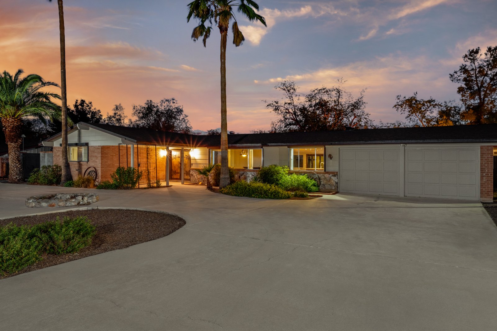 Broad front driveway and garage approach at sunset
