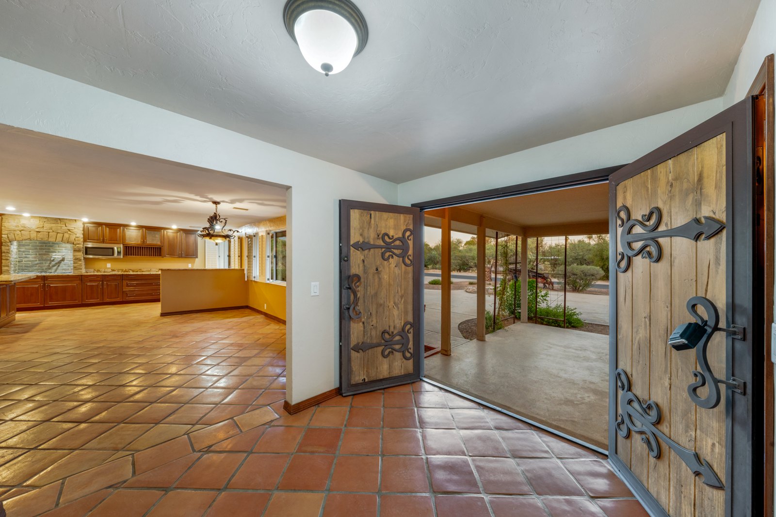 Wood entry door with decorative metalwork opening toward the living area