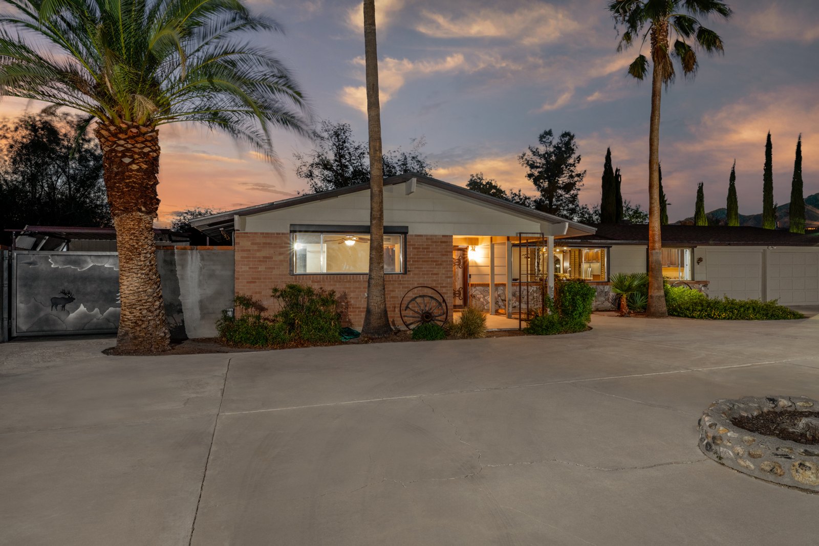 Brick exterior and entry framed by mature palms