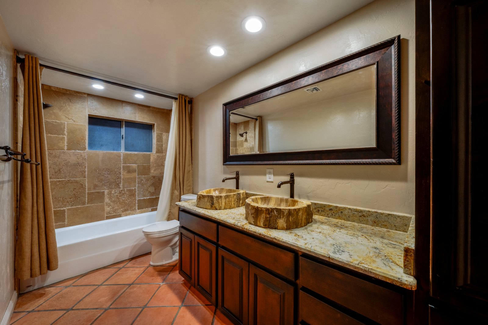 Second bathroom with wood vanity and a tub and shower