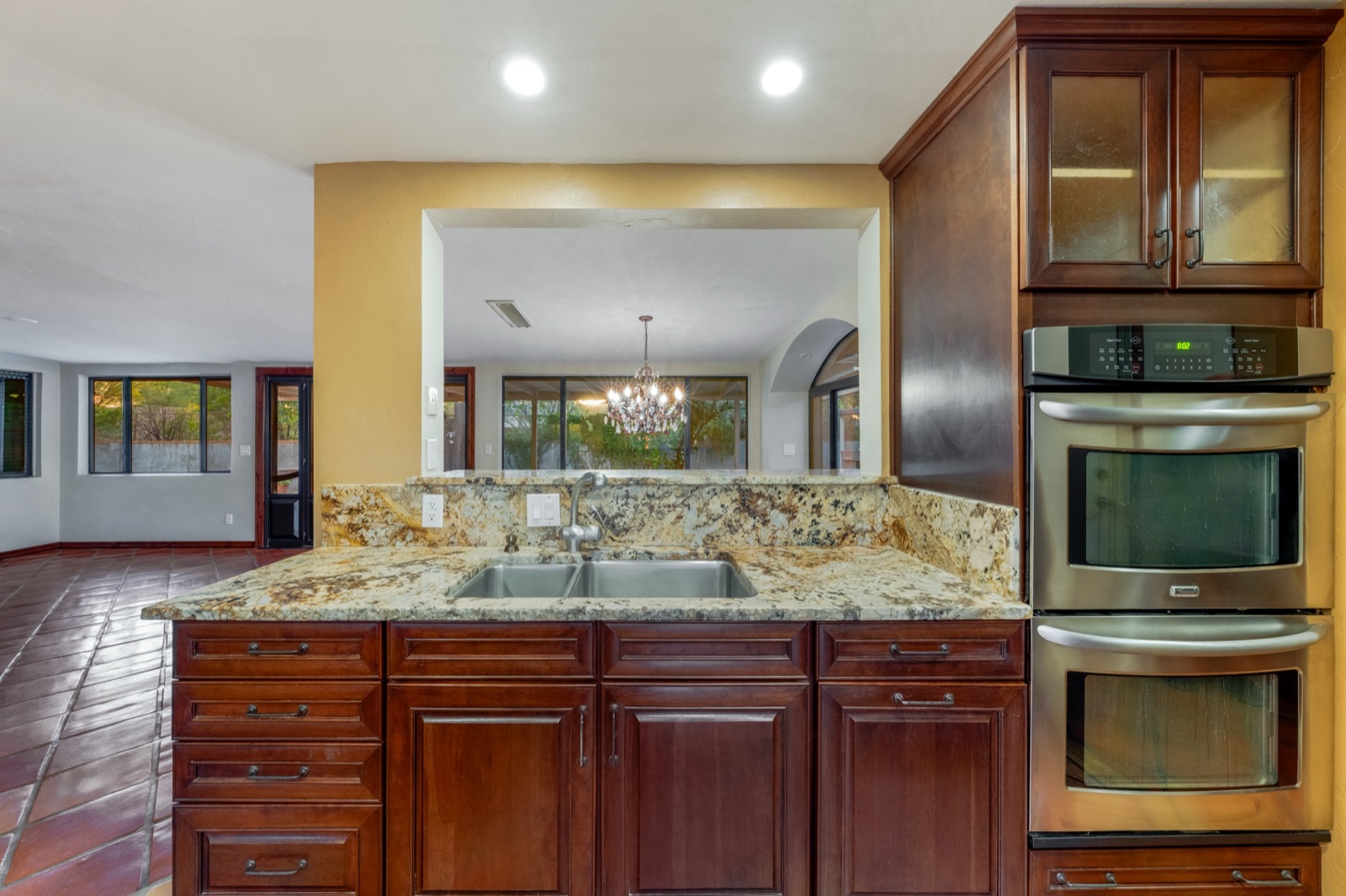 Kitchen detail showing stacked wall ovens, sink and counter space