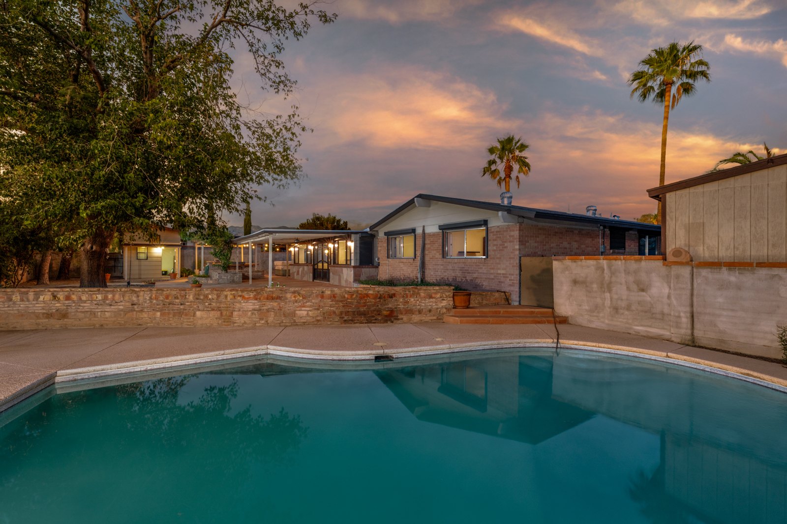 The pool looking back toward the residence and patio at dusk
