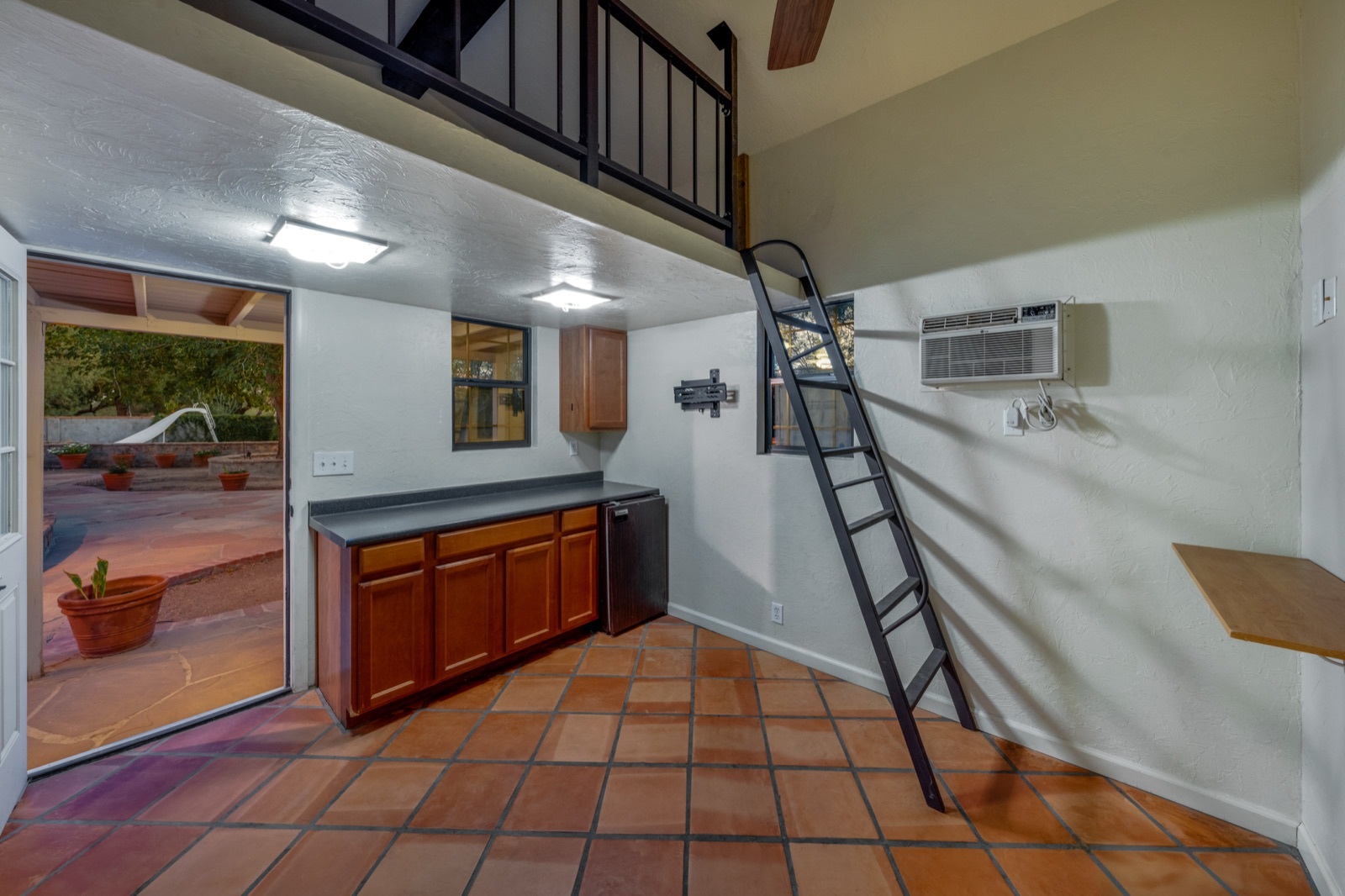 Detached bonus space with a loft, ladder, cabinets and wall-mounted air conditioning