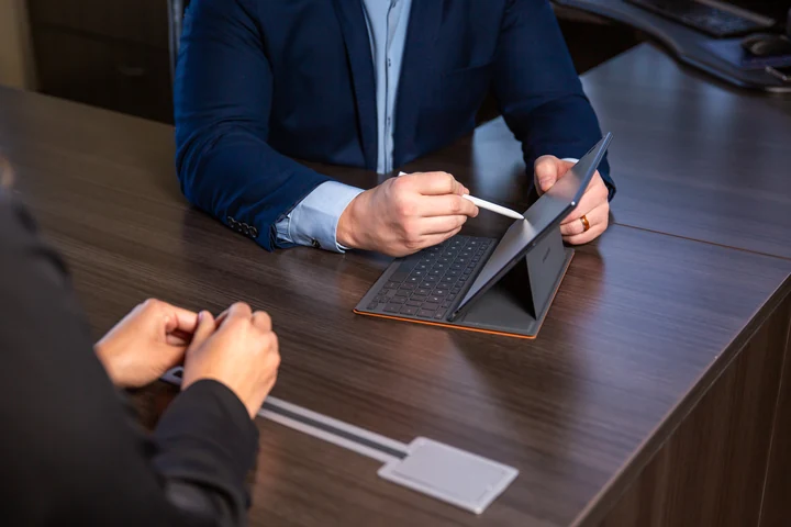 A conversation over the details, with a tablet and notes on the table